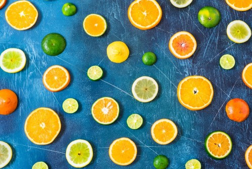 wzor-cytrusowy-na-niebieskim-tle-rozne-owoce-cytrusowe-plastry-pomaranczy-mandarynki-cytryny-limonki-widok-z-gory