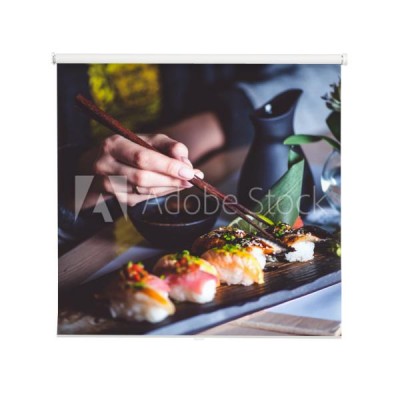 mezczyzna-jedzenie-zestaw-sushi-z-paleczkami-w-restauracji